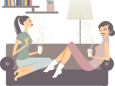 female friends with coffee cups talking at home