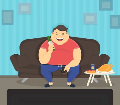 Fat man sitting at home on the sofa watching tv and drinking beer