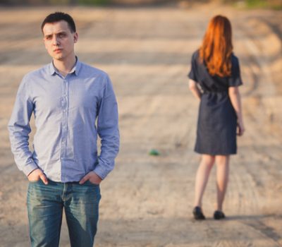 sad man and woman stand on the dirt road
